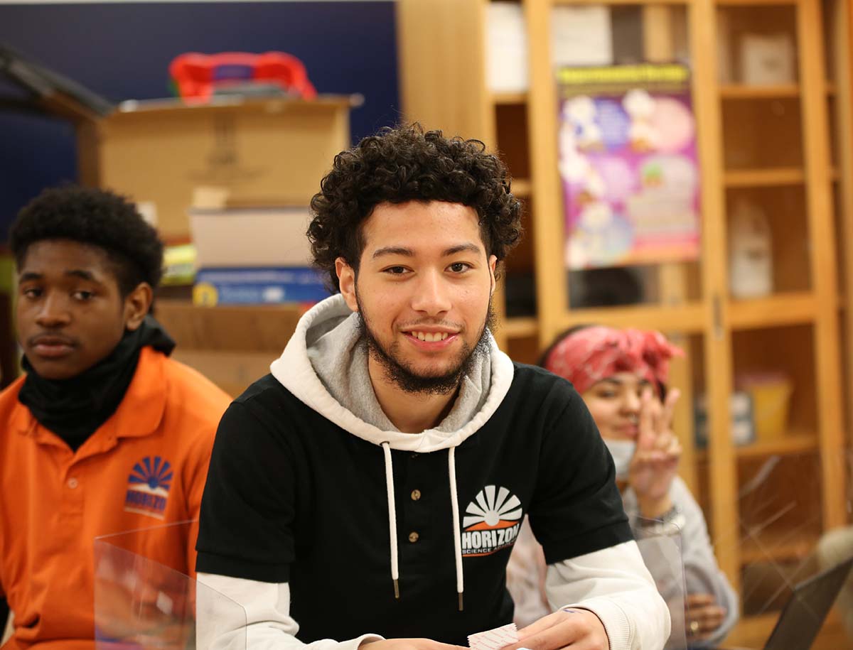 Elementary student smiling and posing together in a classroom.